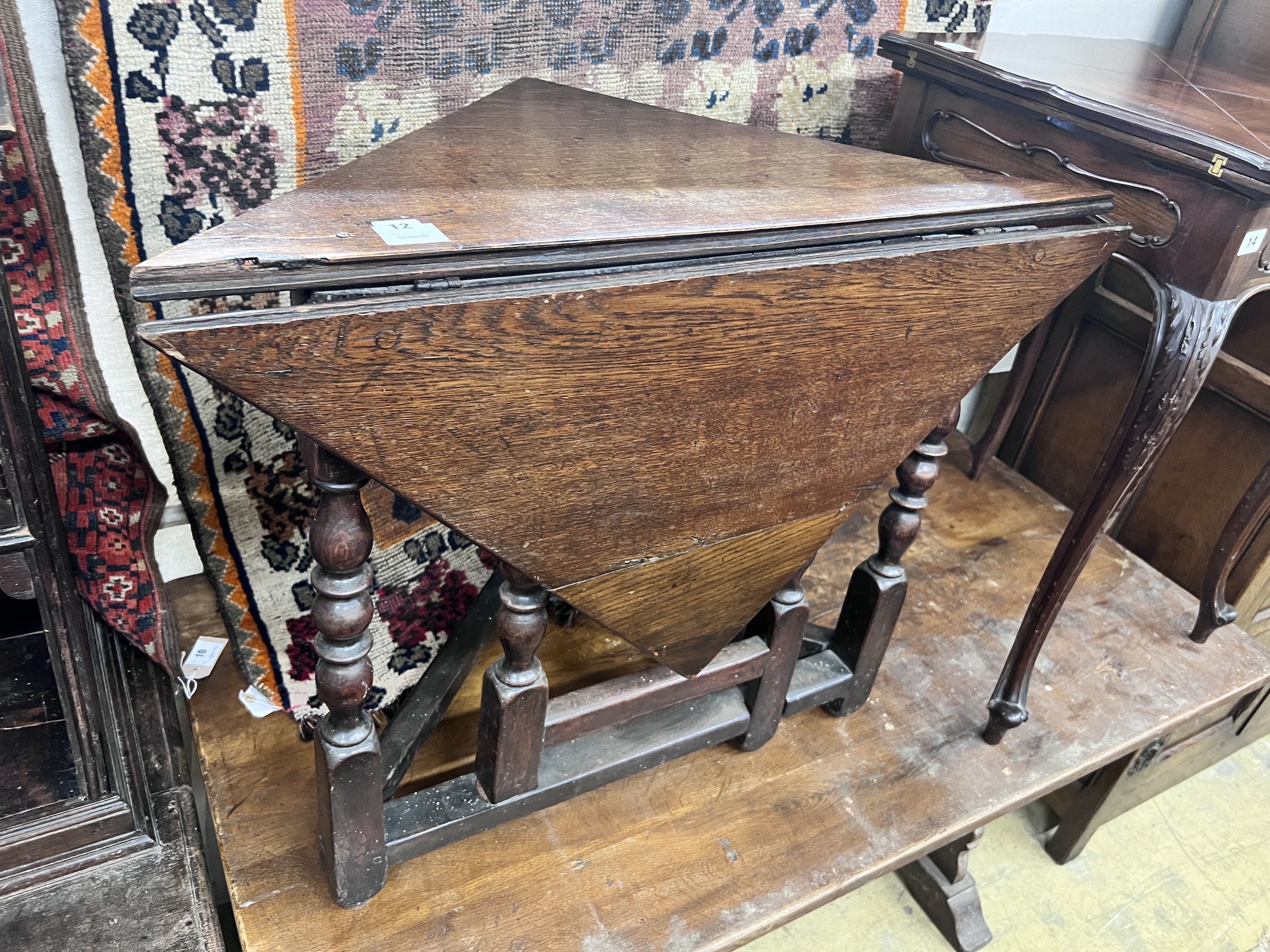 An 18th century oak triangular drop leaf table, width 86cm, depth 45cm, height 69cm